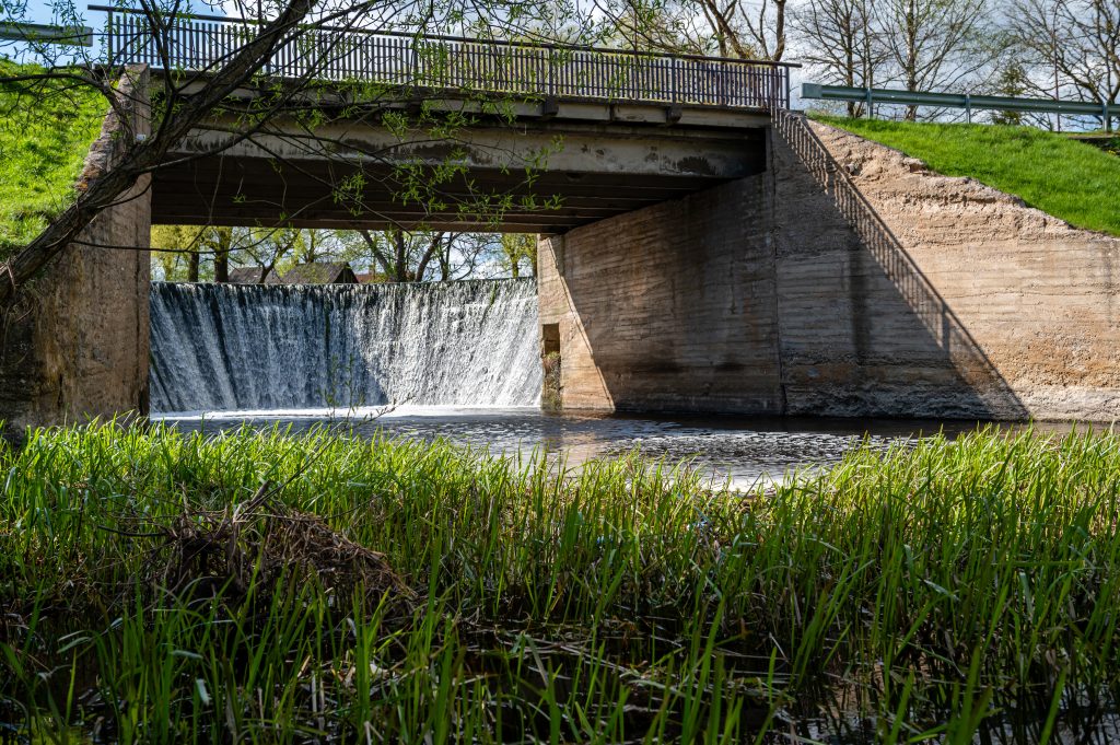 small dam on a small river in the countryside in springtime.